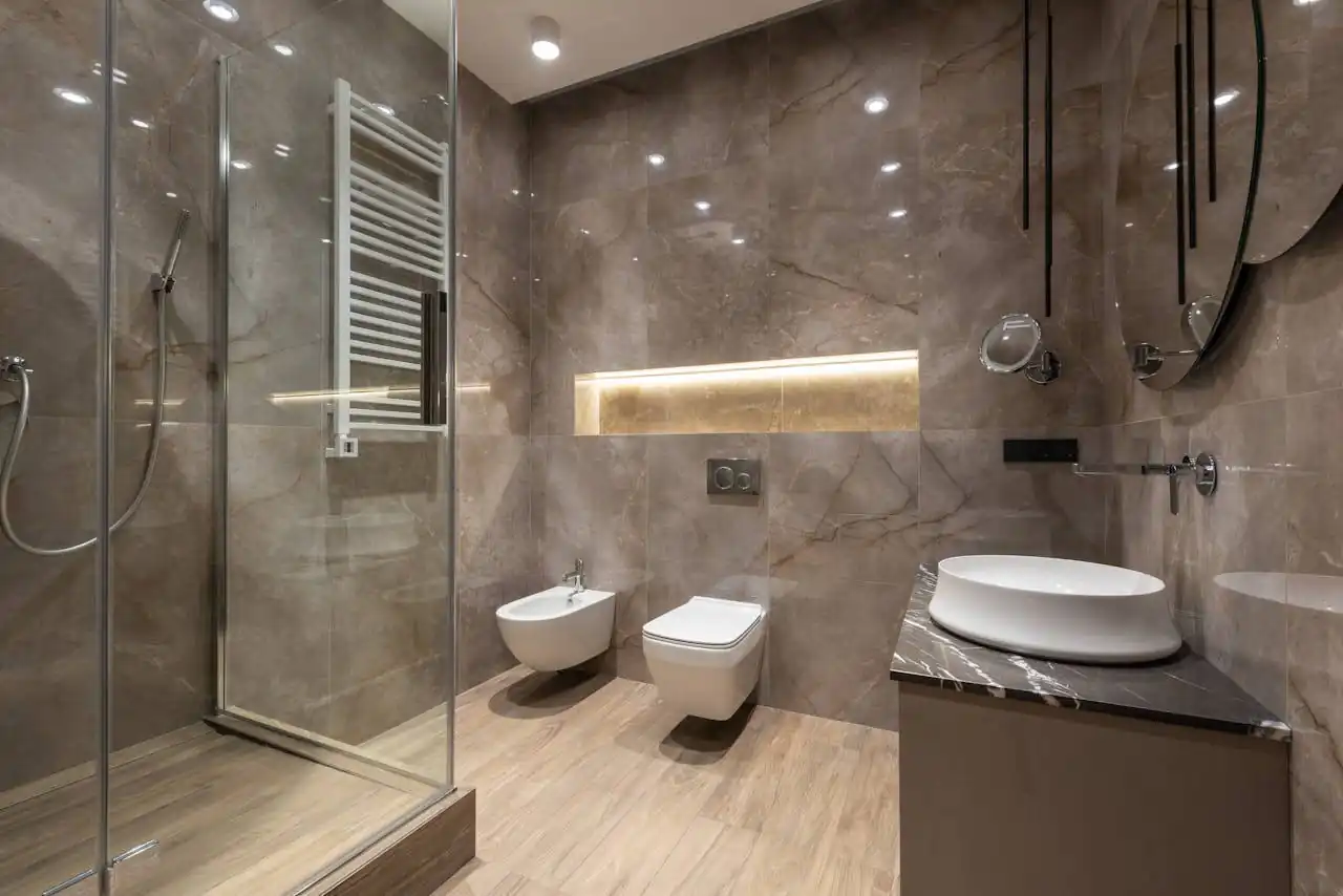 Paredes de baño revestidas con porcelánico de gran formato con acabado que imita mármol natural