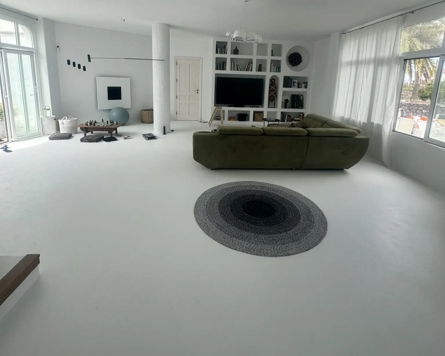 Suelo de microcemento continuo sin juntas en salón moderno minimalista