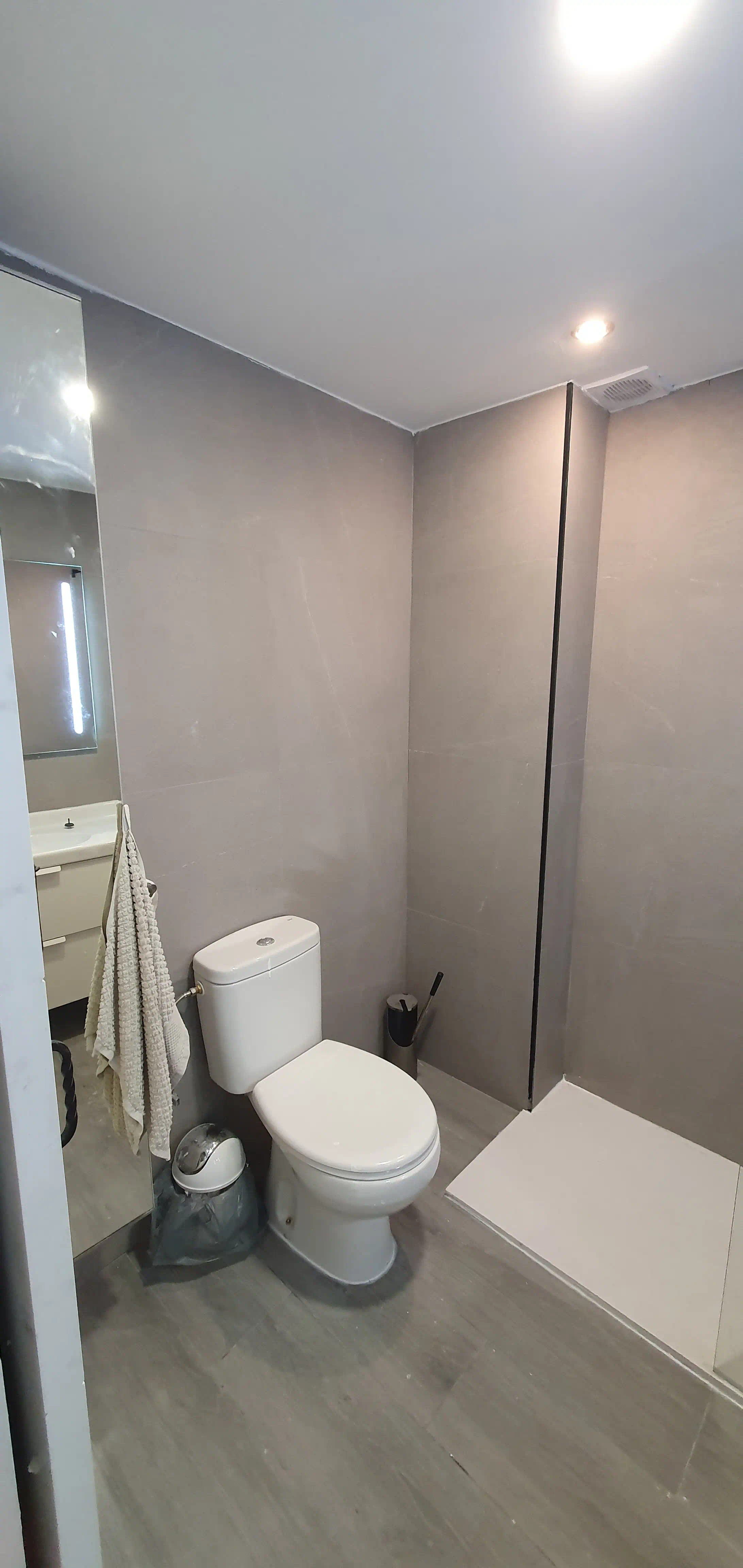 Detalle de acabados premium en baño principal: mueble ROCA, poceta e iluminación LED
