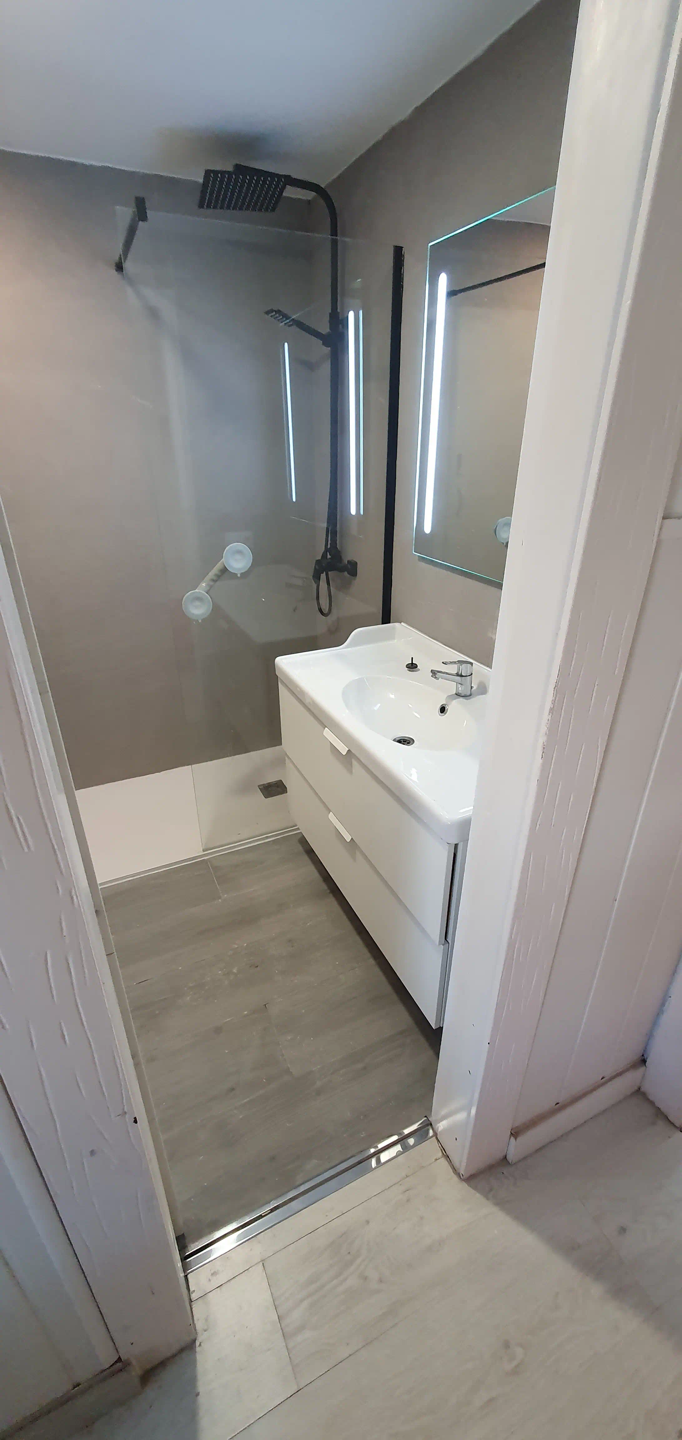 Perspectiva integral del baño principal renovado con luces LED 6500K
