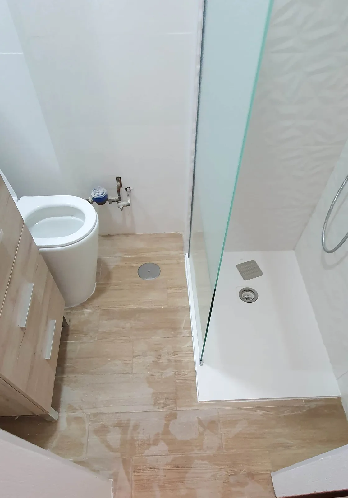 Suelo finalizado en porcelanato imitación madera roble en baño pequeño