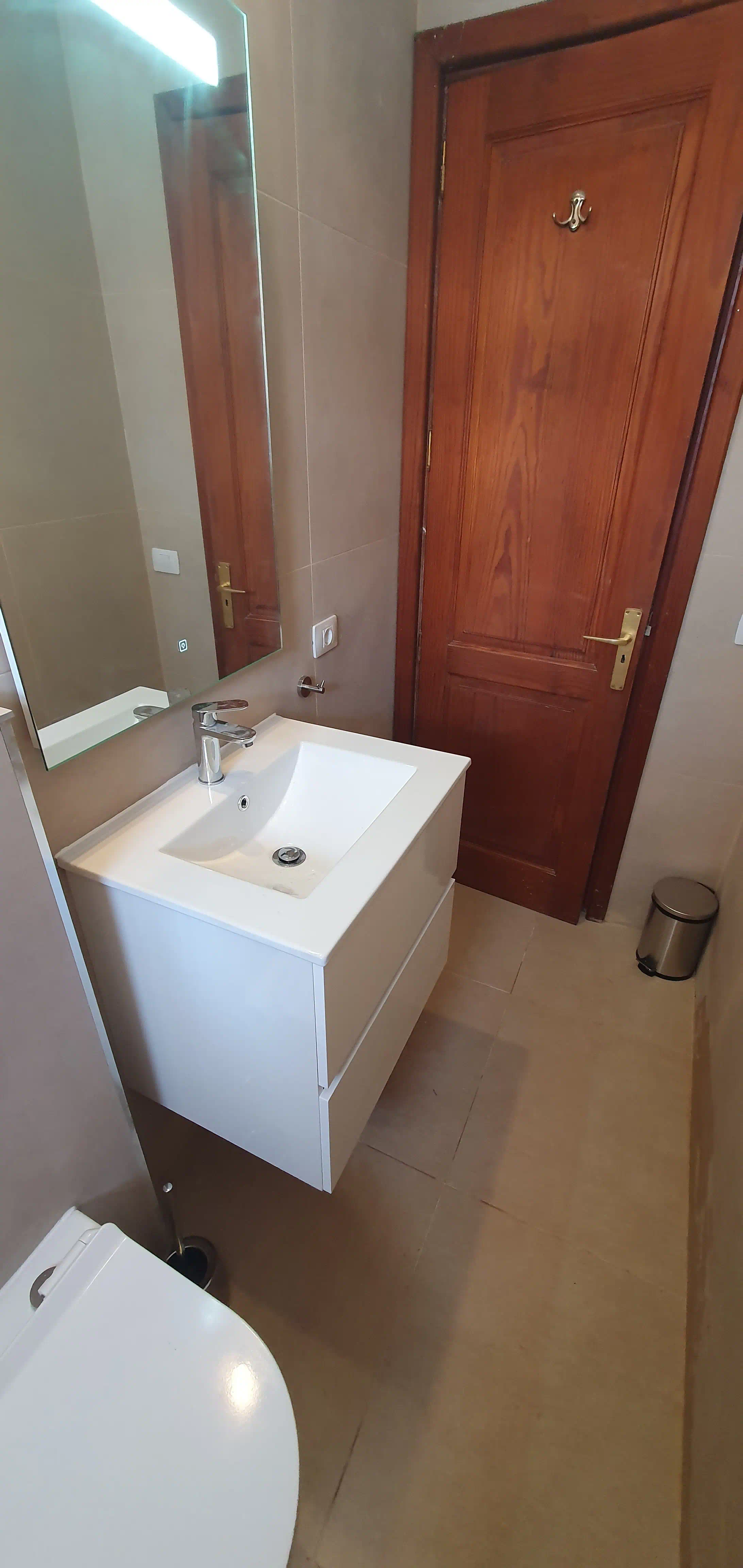 Perspectiva completa del baño residencial en San Diego en porcelanato beige rectificado