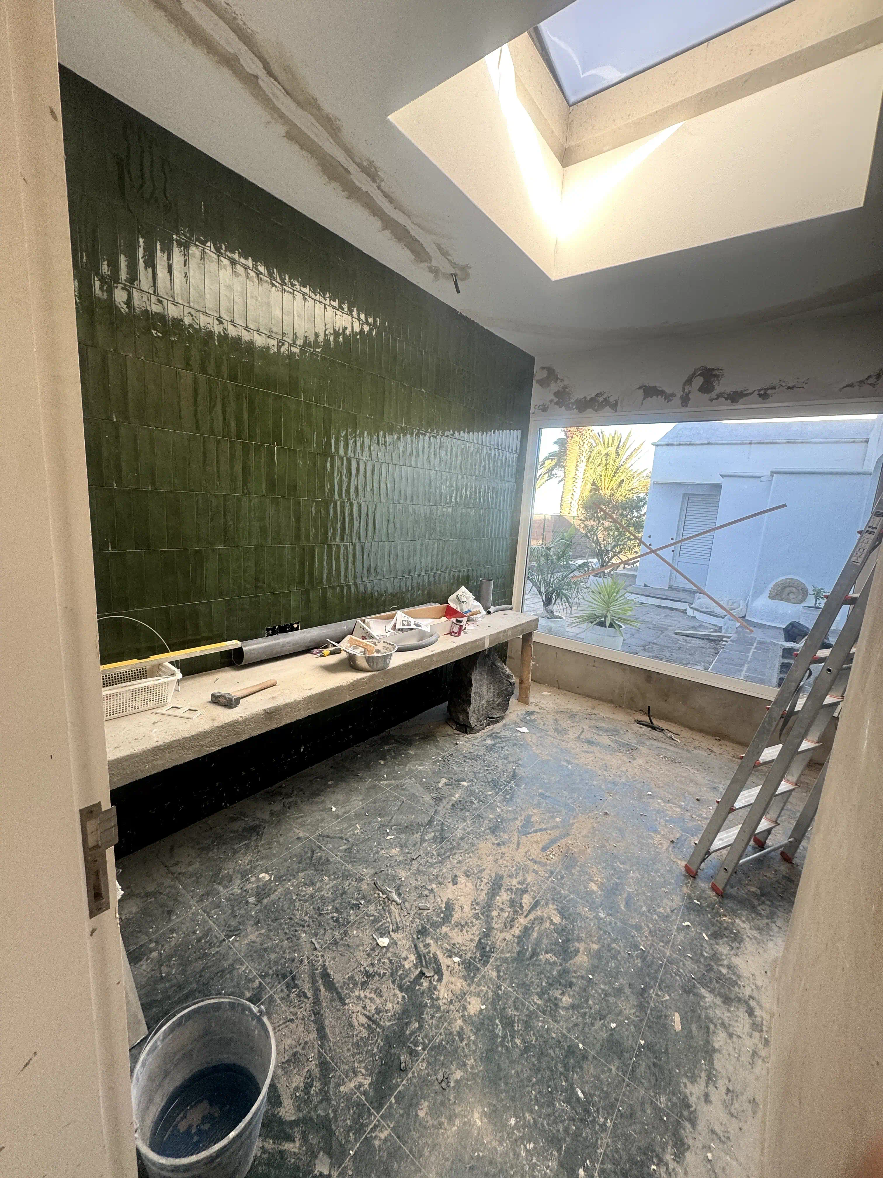 Instalación del porcelanato tipo metro en color verde esmaltado en paredes de lavabo