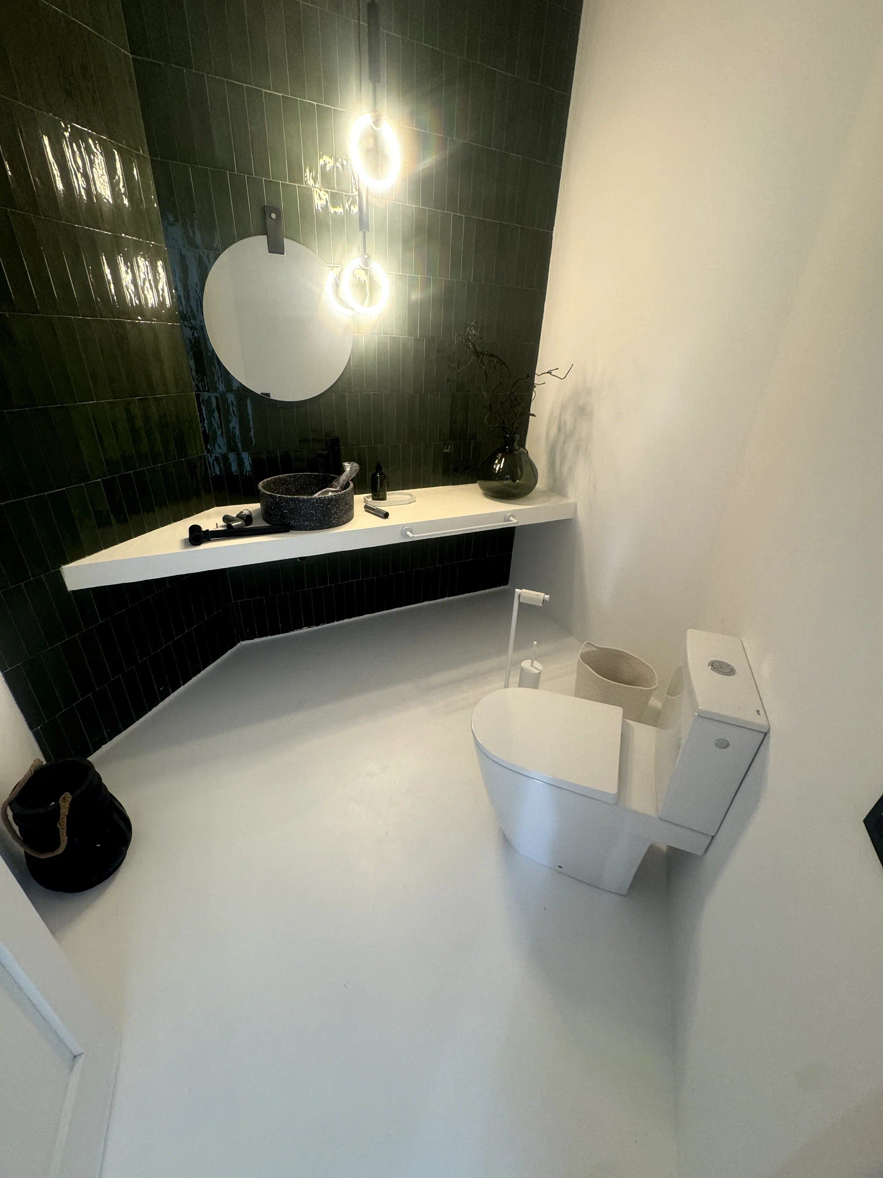 Sala sanitaria independiente con inodoro ROCA importado, microcemento y porcelanato metro verde
