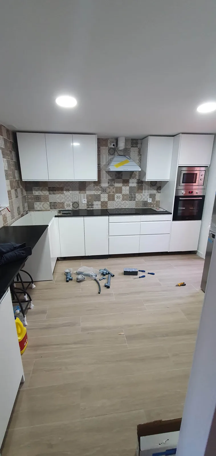 La misma cocina de Caracas terminada con mobiliario blanco y electrodomésticos integrados