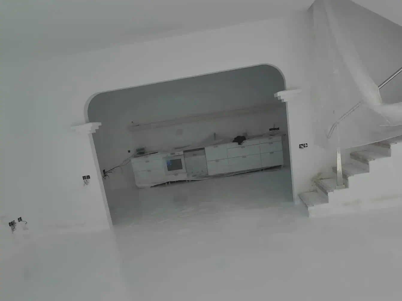 Cocina en proceso de montaje vista desde la sala con el suelo epóxico terminado