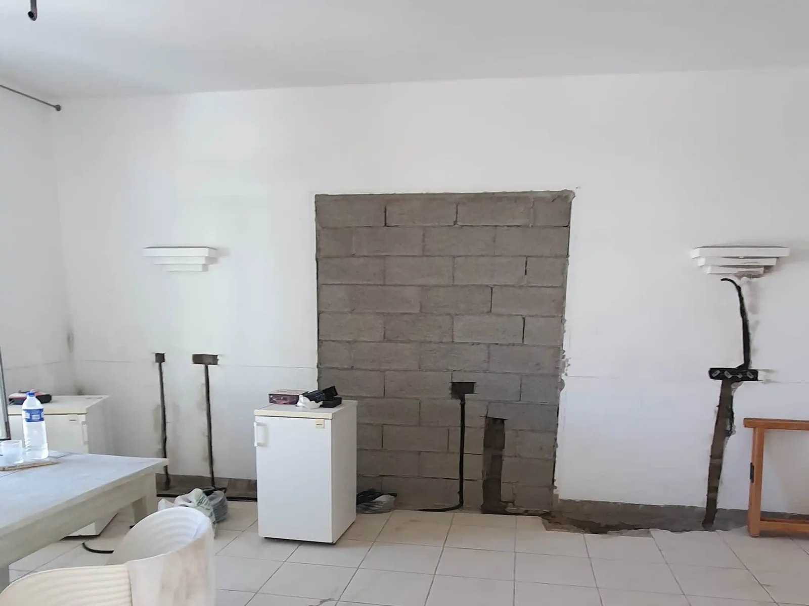 Tabique de bloque condenando el acceso antiguo y ranuras eléctricas en las paredes